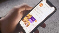 A hand holding a phone. On screen is The Globe Church's Instagram account.