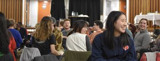 A group from The Globe Church gathering to pray in a school hall.