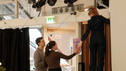 Three people working to set up a room before a church service