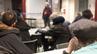 A group of people at Webber Street Day Centre, looking towards someone leading an activity